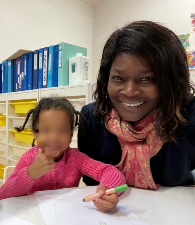 Assistante maternelle avec un enfant en activité de dessin